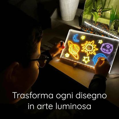 Bambino che colora pianeti sulla lavagna LED al buio