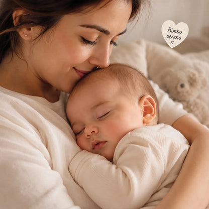 Mamma che bacia il suo bimbo sereno che dorme